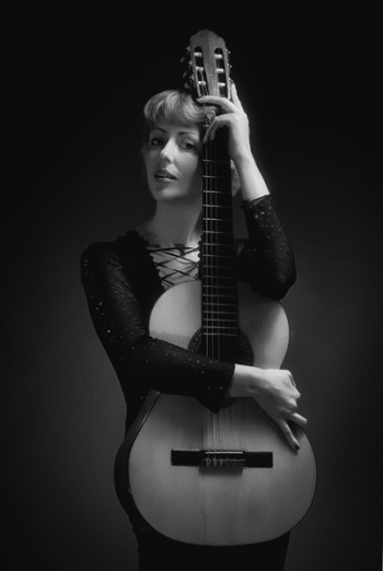 Woman in Black Long-sleeved Dress Holding Classical Guitar