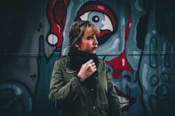 woman in green coat near graffiti woman in green coat near graffiti