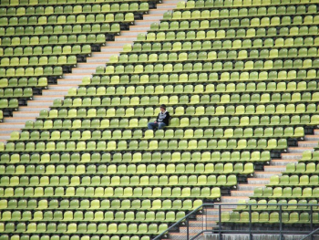 Woman in Grey Shirt Sitting on Stadium Chair