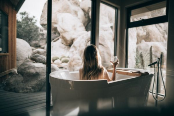 woman in white bathtub holding clear drinking glass woman in white bathtub holding clear drinking glass