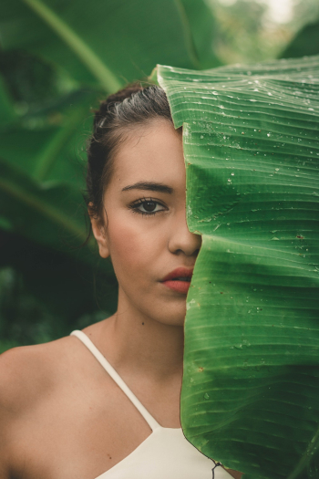 Woman in White Spaghetti Strap Tank Top Looking from Banana Leaves Woman in White Spaghetti Strap Tank Top Looking from Banana Leaves
