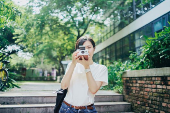 woman in white T-shirt using camera