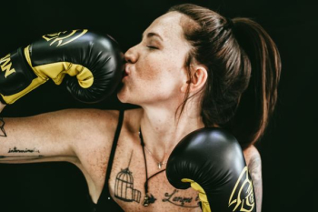 woman kissing black leather boxing gloves woman kissing black leather boxing gloves