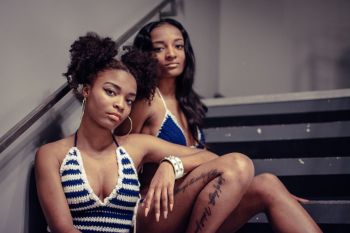 Woman Leaning On Another Woman While Sitting Woman Leaning On Another Woman While Sitting