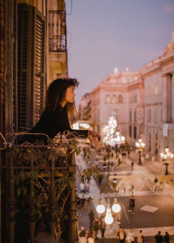 woman leaning on balcony fence