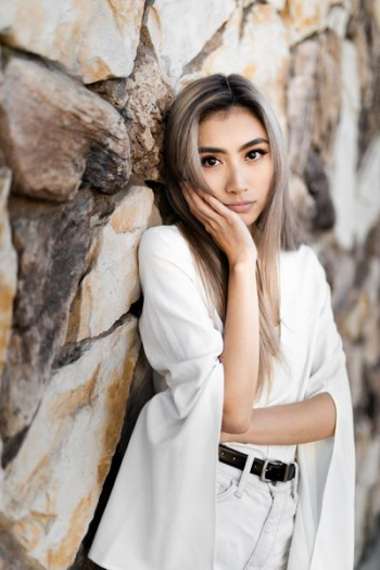 woman leaning on rock wall woman leaning on rock wall