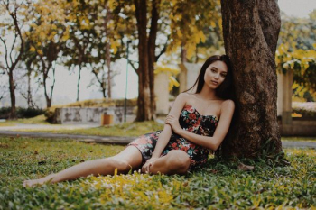 woman leaning on tree during daytime