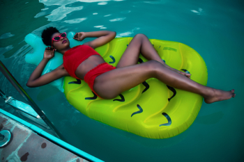 Woman Lying on Green Float Wearing Red Bikini Woman Lying on Green Float Wearing Red Bikini