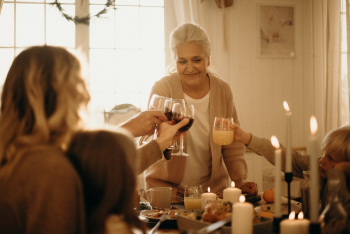 Woman on Gray Cardigan Standing Near Table Doing Cheers Woman on Gray Cardigan Standing Near Table Doing Cheers