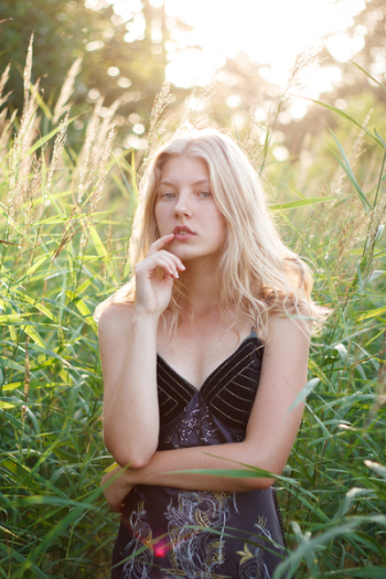 Woman Pointing Her Lips While Standing Beside Plants