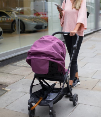 Woman Pushes Stroller While Using Phone Woman Pushes Stroller While Using Phone