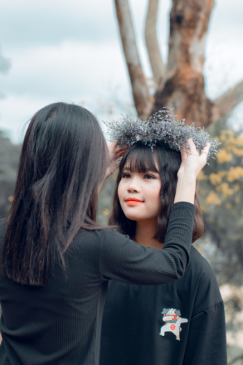 Woman Putting Crown on Women&#39;s Head