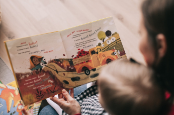 Woman Reading Book to Toddler Woman Reading Book to Toddler