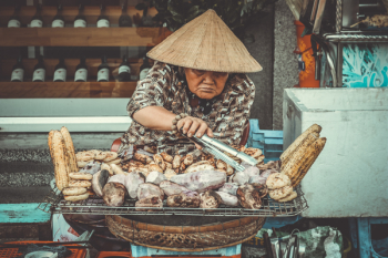 Woman Selling Grilled Root Crops Woman Selling Grilled Root Crops