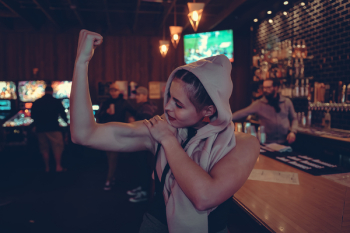 Woman Showing Biceps in Bar Woman Showing Biceps in Bar