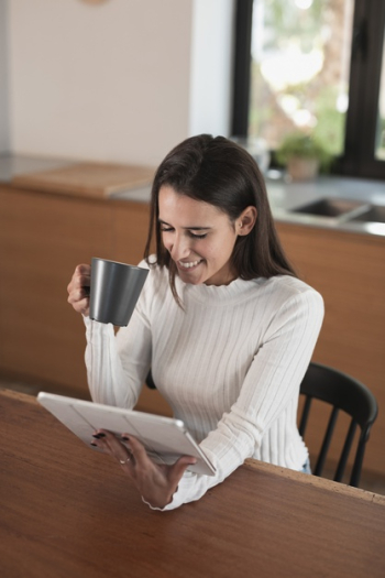 Woman sitting and looking on tablet Free Photo