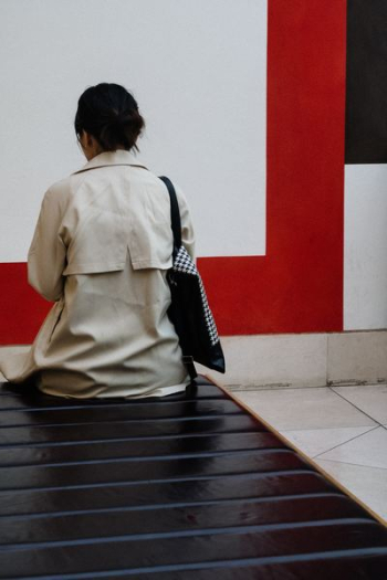 woman sitting fronting white and red wall