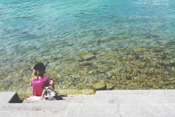Woman Sitting in Front of Sea during Daytime Woman Sitting in Front of Sea during Daytime