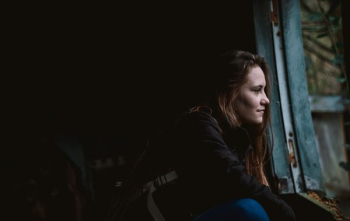 woman sitting next to window