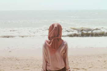 woman sitting on beach shore in front of sea waves woman sitting on beach shore in front of sea waves