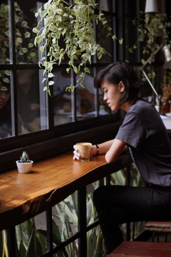 woman sitting on brown wooden chair woman sitting on brown wooden chair