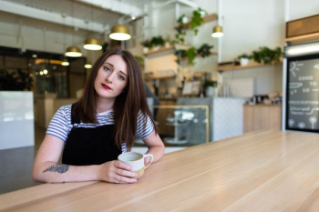 woman sitting on chair while holding mug