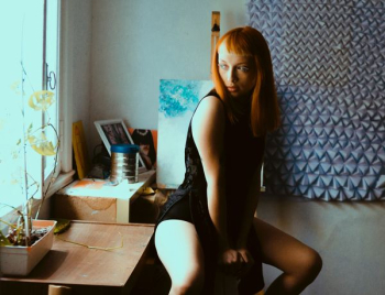 woman sitting on drawer near window woman sitting on drawer near window