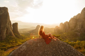 woman sitting on gray rock woman sitting on gray rock