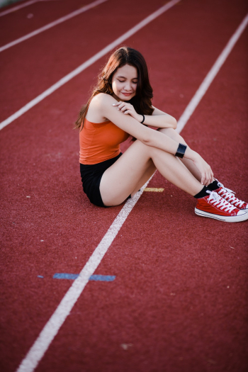 Woman Sitting On Red Track Field Woman Sitting On Red Track Field