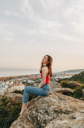 woman sitting on rock during daytime