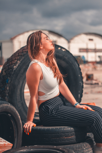 Woman Sitting on Vehicle Tires Woman Sitting on Vehicle Tires