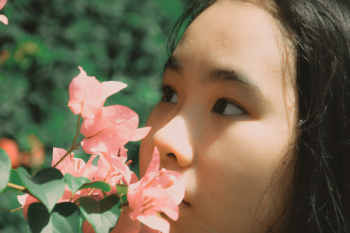 Woman Smelling Pink Bougainvillea Flower