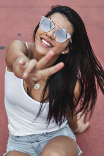 Woman Smiling and Peace Sign Woman Smiling and Peace Sign
