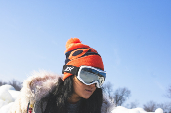 Woman Snowboarding Beside Leafless Trees