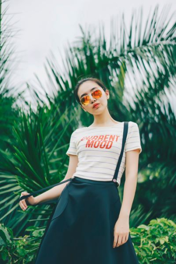 woman standing behind palm plants woman standing behind palm plants