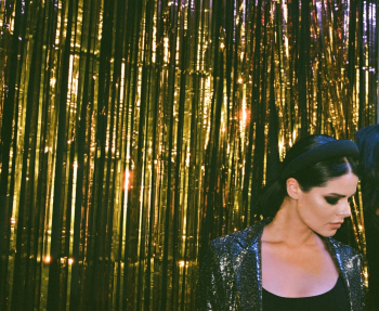 Woman Standing Beside a Gold Foil Curtain Woman Standing Beside a Gold Foil Curtain