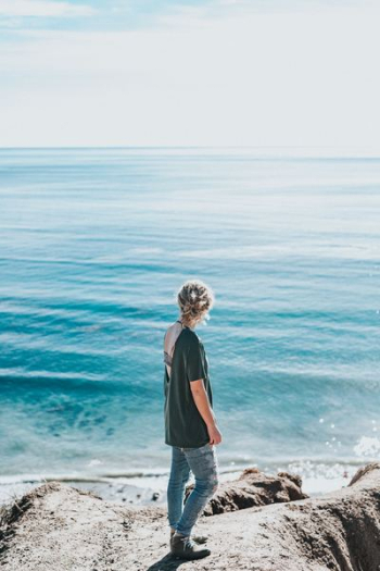 woman standing next to sea woman standing next to sea