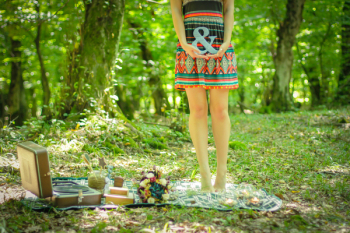 Woman Standing on Picnic Mat Holding Ampersand Lettering Woman Standing on Picnic Mat Holding Ampersand Lettering