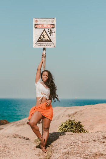 woman standing on sand near body of water during daytime