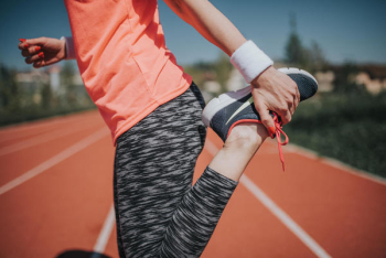 Woman Stretching On Track Field Woman Stretching On Track Field