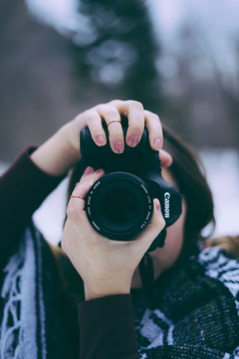 woman taking photography using black Canon EOS camera