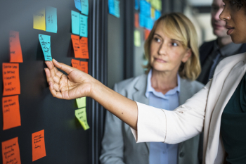 Woman Touching Blue Sticky Note