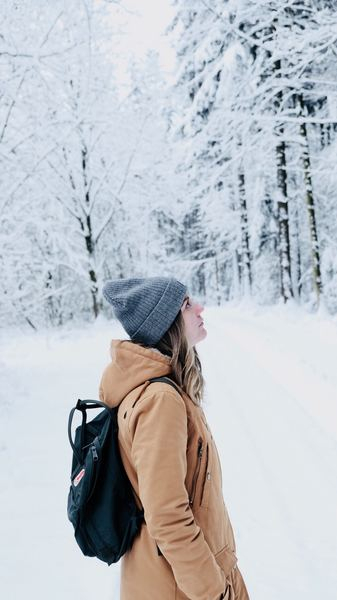 woman walking in snow covered forest woman walking in snow covered forest