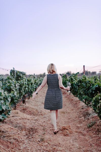 woman walking on vineyard holding wine glass woman walking on vineyard holding wine glass