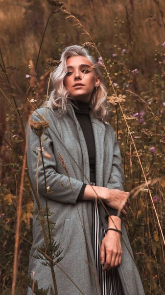 woman wearing black cardigan standing on grass field