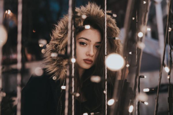 woman wearing black jacket near black string light