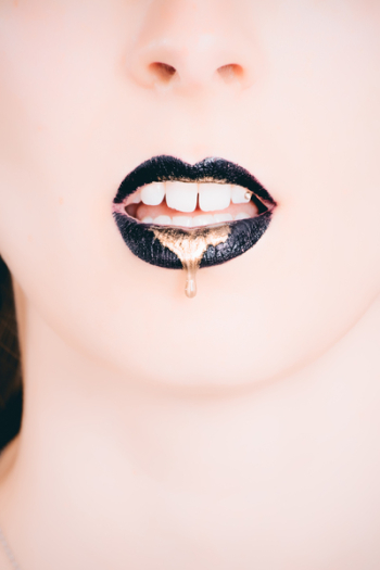 Woman Wearing Black Lipstick With Gold Dripping Out Woman Wearing Black Lipstick With Gold Dripping Out