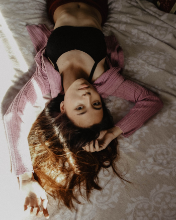 Woman Wearing Black Sport Bra Lying on Bed Woman Wearing Black Sport Bra Lying on Bed