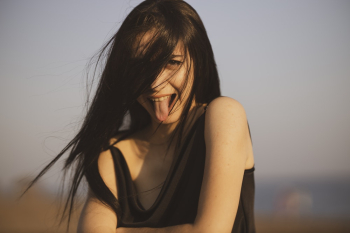 Woman Wearing Black Tank Top Sticking Her Tongue Out Woman Wearing Black Tank Top Sticking Her Tongue Out