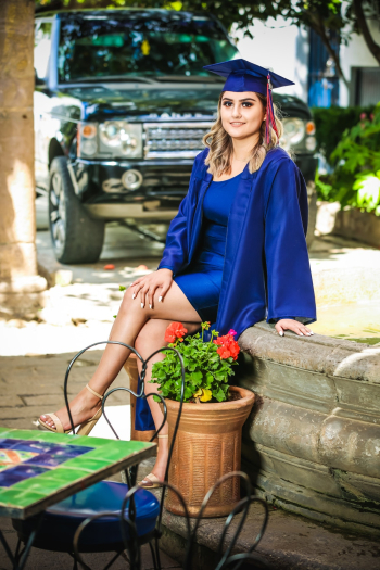 Woman Wearing Blue Graduation Gown Sitting Besides Potted Plant Woman Wearing Blue Graduation Gown Sitting Besides Potted Plant